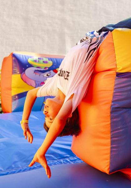 Bambino che gioca su un gonfiabile colorato con clown.