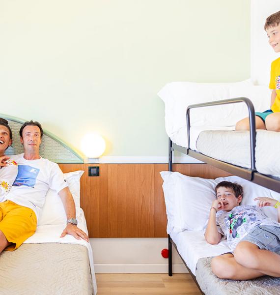 Famiglia felice e rilassata in una camera d'albergo, sorrisi e gioia.